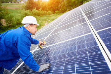 İnşaat işçisi Fotoğraf volta panel güneş sistemi için tornavida kullanarak bağlanır. Profesyonel yükleme ve güneş sistemi, alternatif enerji ve finansal yatırım konsept İnşaat.