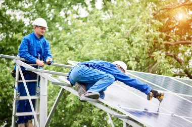 Takım iki kurucusu Fotoğraf volta paneli tornavida kullanarak tek başına güneş sistemi platformu için bağlanma. Alternatif enerji, profesyonel iş ve karlı finansal yatırım kavramı yapılır.