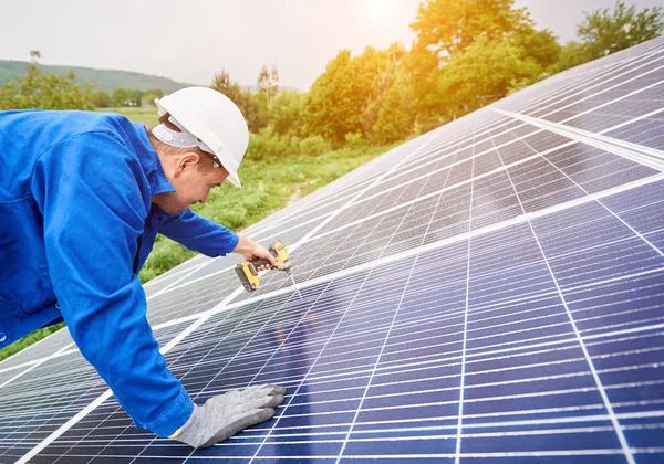 建筑工人用螺丝刀将光电面板与太阳能系统连接起来 太阳能系统专业安装与建设 替代能源与金融投资理念 — 图库照片