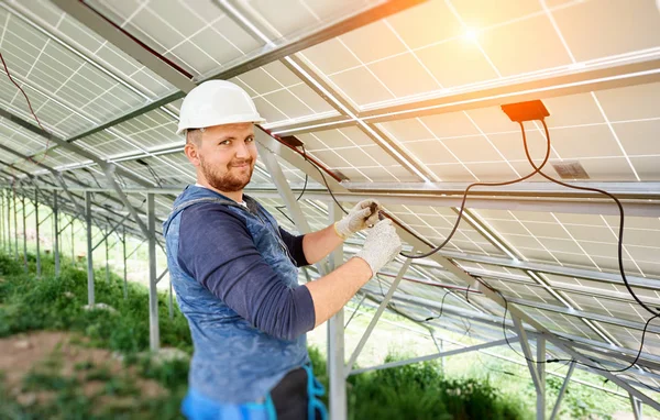独立太阳能光电面板系统的安装和布线 在太阳能电池组件内的硬帽连接电缆中 年轻电工的特写 替代能源概念 — 图库照片
