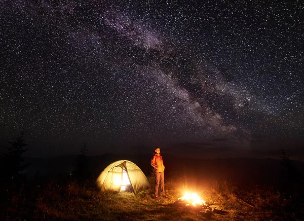 Nocy Camping Górach Turystyczna Kobieta Stojąc Pobliżu Oświetlony Namiot Jasno — Zdjęcie stockowe