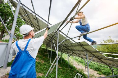 Güneş Fotoğraf volta panel sistem kurulumu. Üç teknisyenler ağır güneş pili yüksek üzerinde kaldırma. Yatırım alternatif enerji, para tasarrufu ve profesyonel inşaat kavramı.