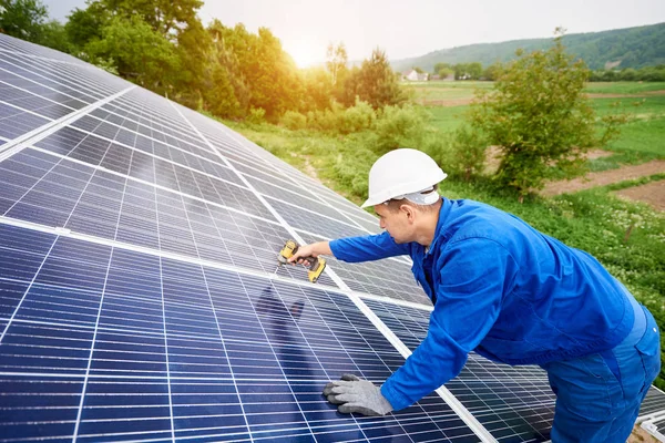 建筑工人用螺丝刀将光电面板与太阳能系统连接起来 太阳能系统专业安装与建设 替代能源与金融投资理念 — 图库照片