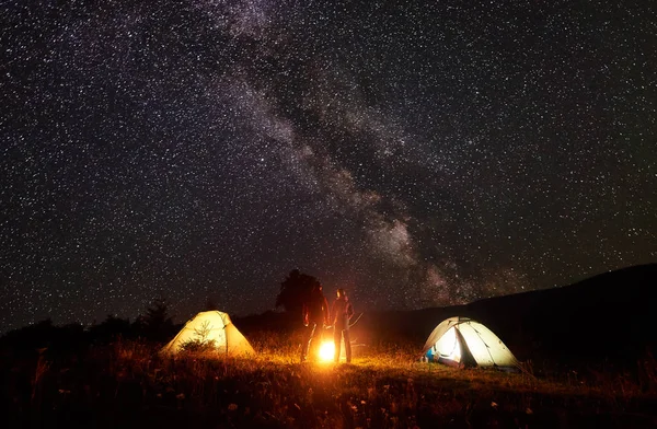 Acampamento Nocturno Nas Montanhas Silhuetas Homem Mulher Frente Tendas Brilhantes — Fotografia de Stock