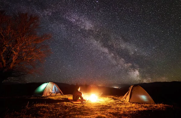 Zelten Den Bergen Wanderer Sitzen Zwischen Zwei Beleuchteten Zelten Auf — Stockfoto