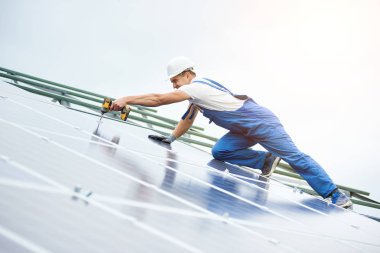 İnşaat işçisi Fotoğraf volta panel güneş sistemi için tornavida kullanarak bağlanır. Profesyonel yükleme ve güneş sistemi, alternatif enerji ve finansal yatırım konsept İnşaat.