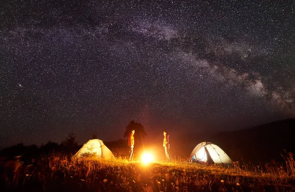 캠핑입니다 모닥불 등산객 남자와 놀라운 어두운 밤하늘은 배경에서 텐트를 빛나는 — 스톡 사진