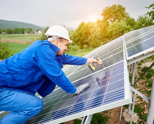 建筑工人在硬帽和蓝色整体连接光电面板与太阳能系统使用螺丝刀 另类廉价太阳能生产与有利可图的金融投资理念 — 图库照片