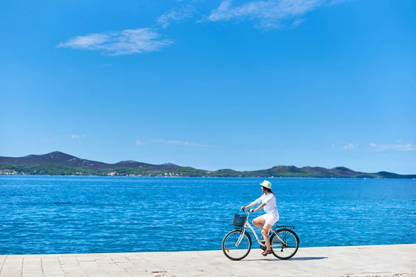 Schöne Radfahrerin Weißem Sommeranzug Und Hut Auf Dem Steinigen Bürgersteig — Stockfoto