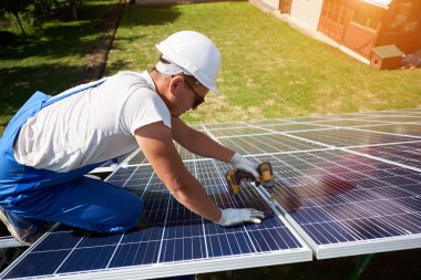 Farklı kullanýlýyor, miğfer profesyonel çalışan güneş panelleri yeşil metal konstrüksiyon üzerinde yükleme. Enerji çözümü için yenilikçi çözüm. Yenilenebilir kaynakları kullanın. Yeşil enerji.