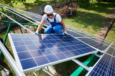 Farklı kullanýlýyor, miğfer profesyonel çalışan güneş panelleri yeşil metal konstrüksiyon üzerinde yükleme. Enerji çözümü için yenilikçi çözüm. Yenilenebilir kaynakları kullanın. Yeşil enerji.