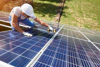 Farklı kullanýlýyor, miğfer profesyonel çalışan güneş panelleri yeşil metal konstrüksiyon üzerinde yükleme. Enerji çözümü için yenilikçi çözüm. Yenilenebilir kaynakları kullanın. Yeşil enerji.