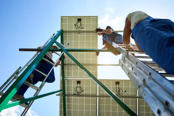 Montadores segurando, instalando painel solar inovador na construção metálica . — Fotografia de Stock