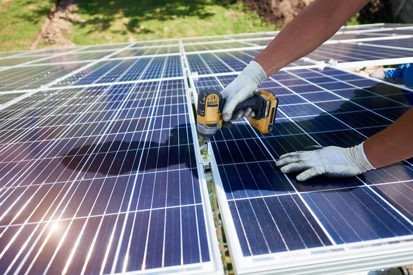 Using drill mounter istalling solar batteries on green metallic carcass. — Stock Photo, Image