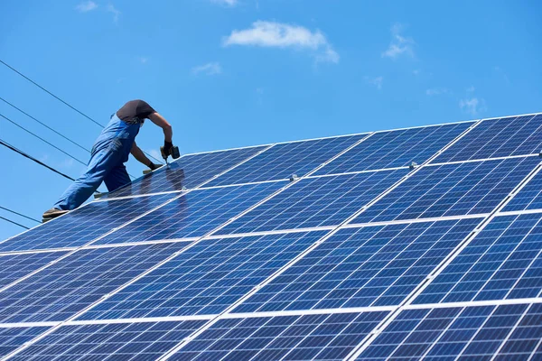 专业的工人安装太阳能电池板上的绿色金属建设 使用不同的设备 戴头盔 解决能源问题的创新方案 使用可再生资源 绿色能源 — 图库照片