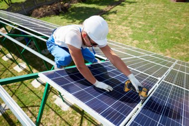 Farklı kullanýlýyor, miğfer profesyonel çalışan güneş panelleri yeşil metal konstrüksiyon üzerinde yükleme. Enerji çözümü için yenilikçi çözüm. Yenilenebilir kaynakları kullanın. Yeşil enerji.