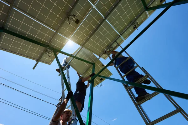 Команда моряків встановлює сонячні батареї на даху будинку . — стокове фото