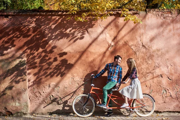 캐주얼 수염된 남자와 빨간색 지직거리 회반죽된 배경에서 자전거 즐기는 여자에 — 스톡 사진