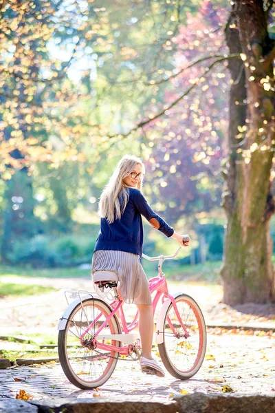 매력적인 치마와 블라우스에 포장된 레이디 자전거 사이클링에 흐리게 노란색 Bokeh — 스톡 사진