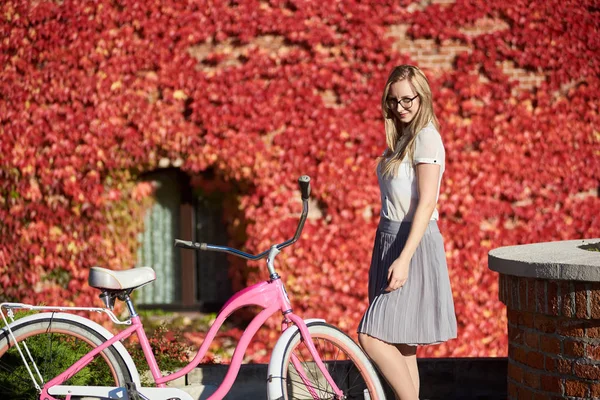 캐주얼 의류와 배경에 잎으로 벽의가 따뜻한 화창한 레이디 자전거에서 — 스톡 사진