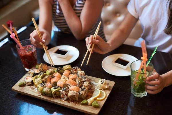 Dua Gadis Yang Sedang Makan Sushi Bergulir Lezat Restoran Disajikan — Stok Foto