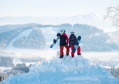 Snowboard birkaç dağlar bembeyaz manzaranın tadını ve Karpatlar dağ tepesinde yükseklikten ormanlarında kış Kayak Merkezi güzel güneşli bir günde. Arkadan Görünüm