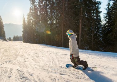 Genç kadın bir güzel kış güneşli akşam boşaltmak güneş ışığı günbatımı parlama rekreasyon resort turizm seyahat yamacında snowboard