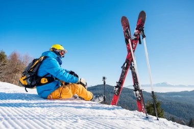Binme kış resort Seyahat keyfi rekreasyon yaşayan insanlar yamaçta Kayak ekipmanlarını güzel karlı dağlarda zevk rahatlatıcı yakın oturan bir kayakçı görüntüsünü göster