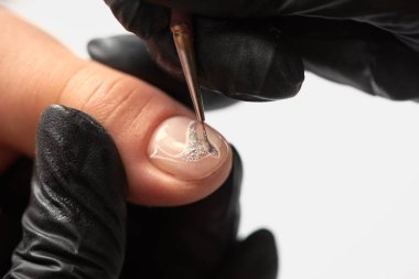 Moda manikür güzellik salonda. Profesyonel manikürcü Close-up istemci üzerinde zarif soyut gümüş desenler kadın çivi ince aplikatör fırçayla boyama siyah lastik eldiven eller.