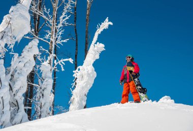 Onun snowboard yaparken bir güneşli kış gün boşaltmak yaşam tarzı zevk rekreasyon sporcu etkinliği insanlar mevsimsel kavramı ile dağın tepesinde duran bir snowboard kadeh.
