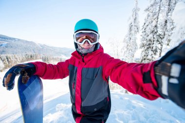 Miğfer, kayak maskesi ve renkli kış snowboard giyim, Kayak Merkezi, dağın tepesinde duran bir adam snowboard bir selfie alarak atış