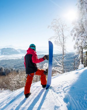 Görünüm boşaltmak kış dağlar zevk çevresinde arıyorum onun snowboard ile bir yamaç üzerinde duran bir erkek snowboard tam uzunlukta çekim yaşam tarzı kavramı manzara.
