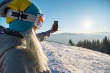 Kadın Snowboard Snowboard, Kış Doğa dağlarda akıllı telefon sabah boşaltmak bağlantı hareketlilik taşıyıcı yaşam tarzı teknoloji kullanılarak fotoğraflarını alarak sonra rahatlatıcı