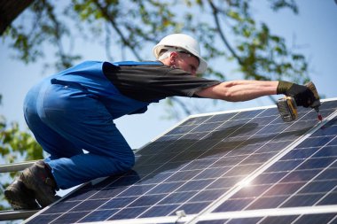 Profesyonel teknisyen tornavida kullanarak metal platforma parlak güneş Fotoğraf volta paneli bağlanma. Dış güneş sistemi yükleme, yenilenebilir yeşil enerji üretimi kavramı.