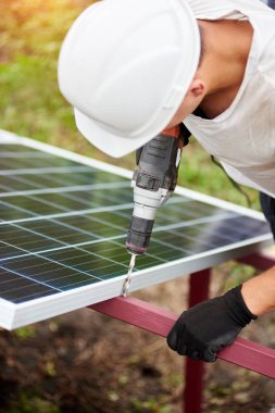 Profesyonel teknisyen tornavida metal platformu üzerinde sıcak güneşli yaz günü güneş Fotoğraf volta paneli bağlanma ile çalışma Close-up. Tek başına dış güneş paneli sistemi kurulması.