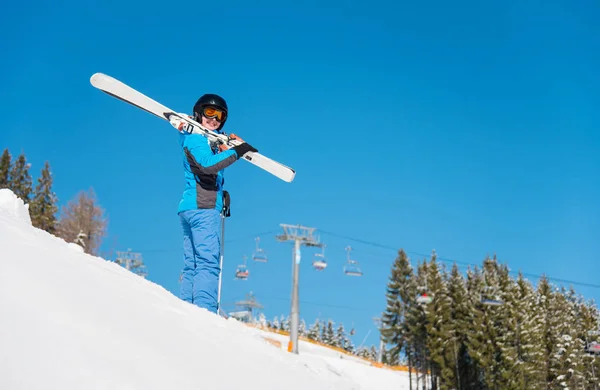 低角度拍摄的女滑雪者在抱着她的肩膀滑雪板的雪山山 蓝蓝的天空 冬季森林和滑雪胜地背景 Copyspace 生活方式女运动员周末概念 — 图库照片