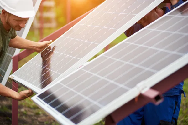 在阳光明媚的夏日温暖的一天 技师团队将大光泽太阳能电池板调整为金属平台 单机外部光电系统安装 可再生生态能源发电理念 — 图库照片