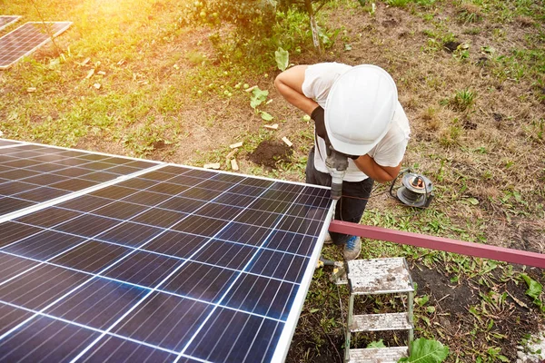 外装金属プラットフォームに晴れた日に太陽光発電パネルを接続するドライバーを使って作業する技術者の上からの眺め 代替再生可能な生態学的なグリーン エネルギー ソースのコンセプト — ストック写真