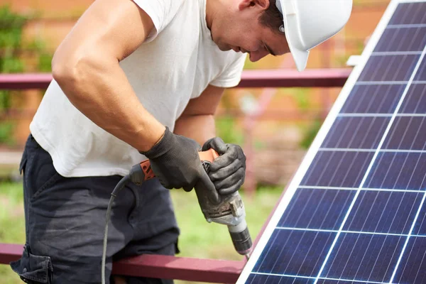 暖かい夏の日に屋外電気ドライバーを使用して金属のプラットフォームに太陽光発電パネルを接続するヘルメットの技術者のクローズ アップ スタンドアロンの太陽電池パネル システム インストールのコンセプト — ストック写真