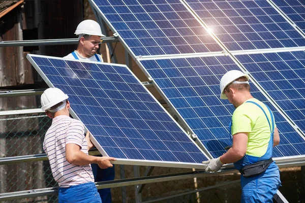 Equipo Tres Jóvenes Técnicos Cascos Protectores Que Instalan Paneles Fotovoltaicos — Foto de Stock