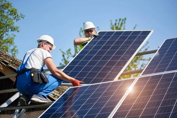 Dos Técnicos Profesionales Que Ajustan Panel Fotovoltaico Solar Pesado Plataforma Imagen de stock