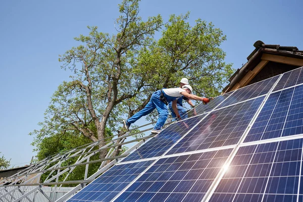 Vista Inferior Dos Técnicos Plataforma Metálica Que Instalan Paneles Solares Imagen de stock