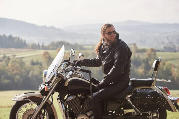 머리에 재킷과 선글라스 크루저 오토바이에 잘생긴 수염된 평화로운 풍경과 흐리게 — 스톡 사진