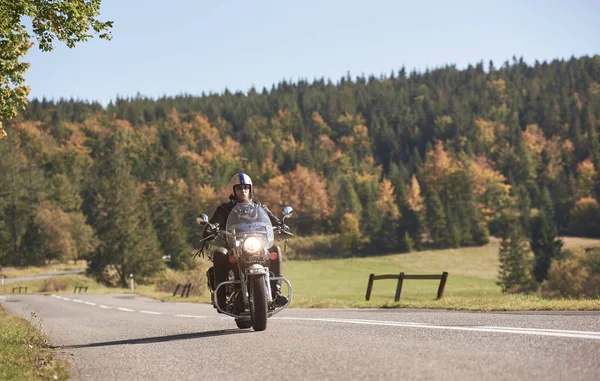 ヘルメット サングラス 明るく晴れた秋の日に空のアスファルトの道路に沿ってクルーザー バイクを乗って黒革衣類のひげを生やしたバイカー — ストック写真