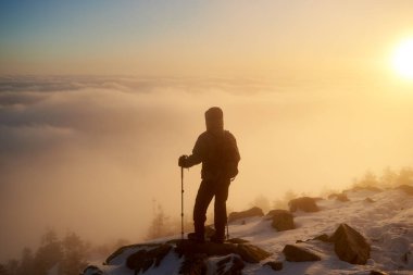 Arkadan görünüşü siluet turist hiker sırt çantası ve kayalık dağ tepe üzerinde sopa hiking 