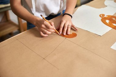 İş yerinde tasarım stüdyosu, profesyonel kadın tasarımcı kağıt desenleri ölçüm kaset, cetvel ve eğrileri kullanarak yapma