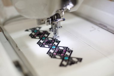 Dikiş makinesi beyaz kumaş üzerine renkli soyut geometrik desen oluşturma, yakın çekim 