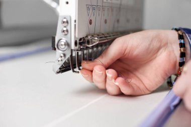 Kadın el parlak arka plan bulanık makinede modern nakış iş parçacığında doldurma yakın çekim
