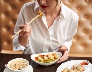 Lüks Japon restoranında yemek sipariş kırmızı dudaklı beyaz bluz kadın görünümünü kırpılmış