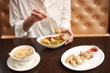 Kız lüks restoranda oturan ve lezzetli yemek yeme beyaz bluz